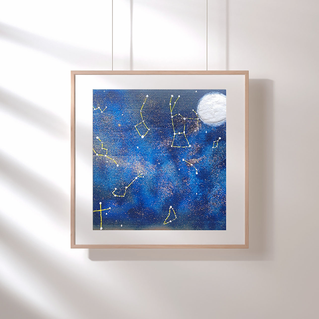 navy blue and light blue galaxy scene. bright white moon in top right corner. glitter sprinkled around the background among bright yellow constellations.